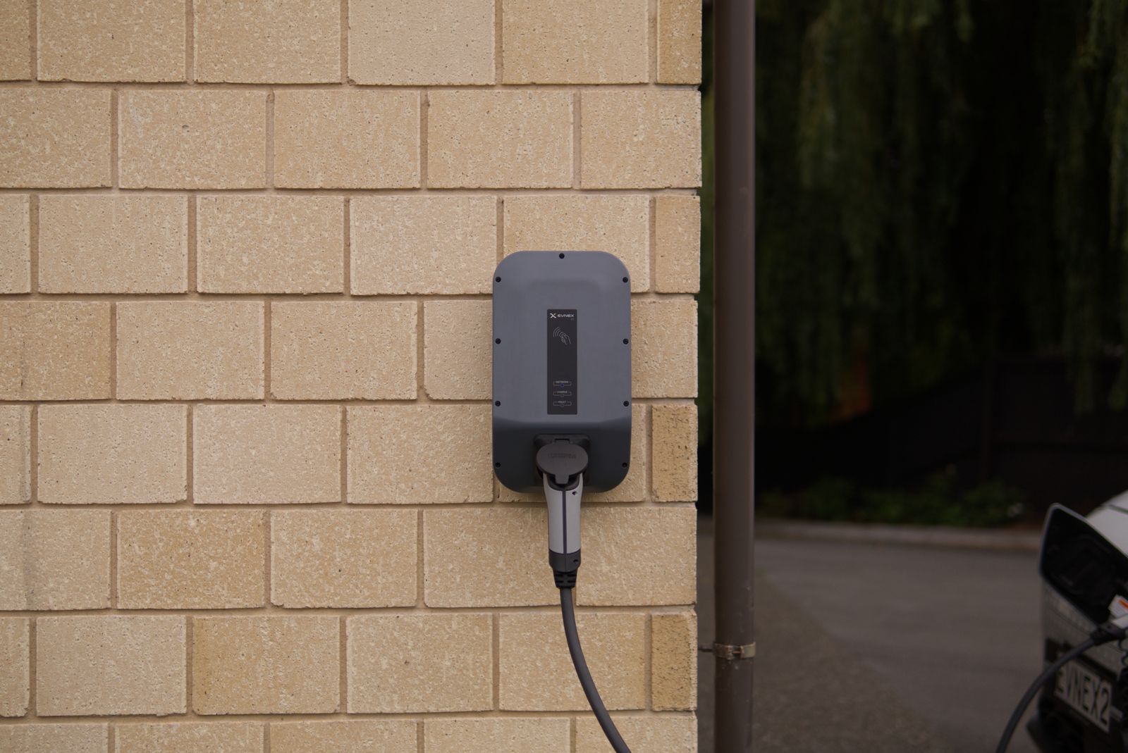 Laadpunt voor een elektrische auto aan een bakstenen muur